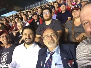 John Ouellette, left, at an Ottawa Redblacks game with Rabbis Tal Scher and Reuven Bulka, and Dan Greenberg, who left himself barely in the frame. Photo by Dan Greenberg
